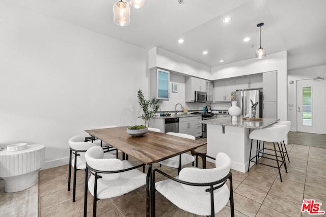 dining space featuring sink and light tile patterned floors