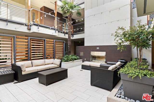 view of patio featuring an outdoor living space with a fireplace