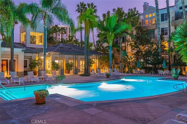 pool at dusk with a patio