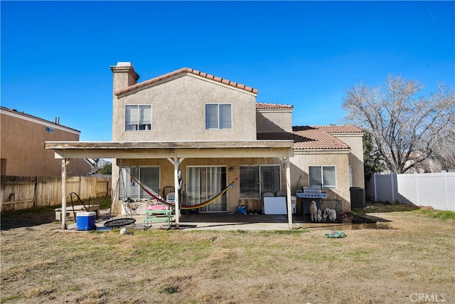 rear view of house with a patio and a yard