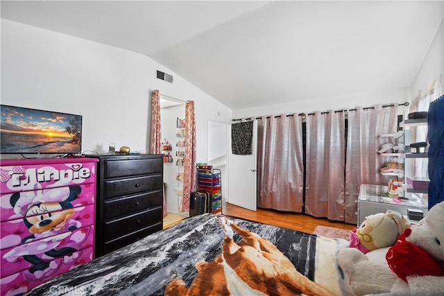 bedroom featuring lofted ceiling and light hardwood / wood-style floors