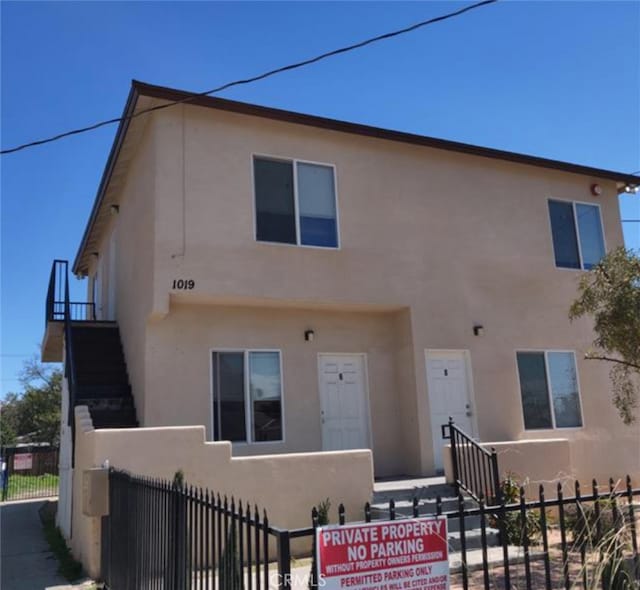 view of front of home with a fenced front yard and stucco siding