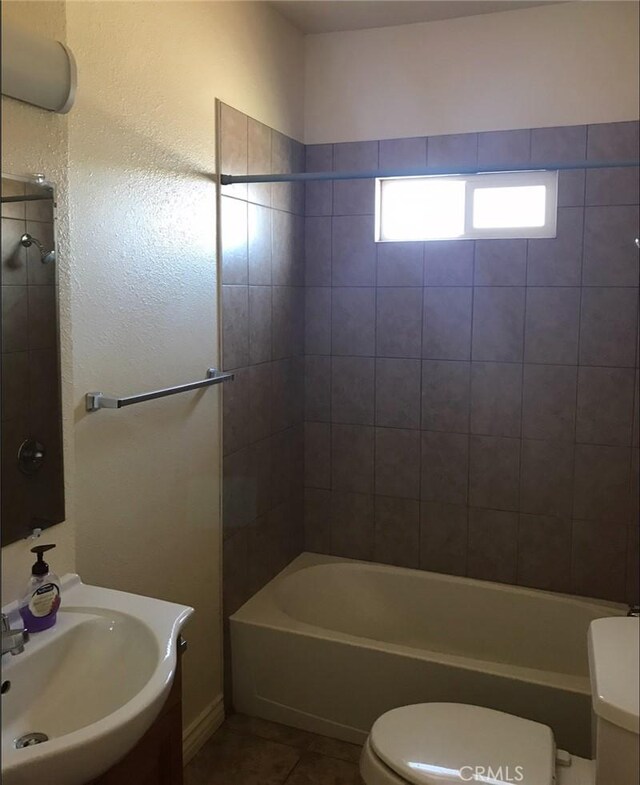 full bathroom featuring sink, tile patterned flooring, tiled shower / bath combo, and toilet