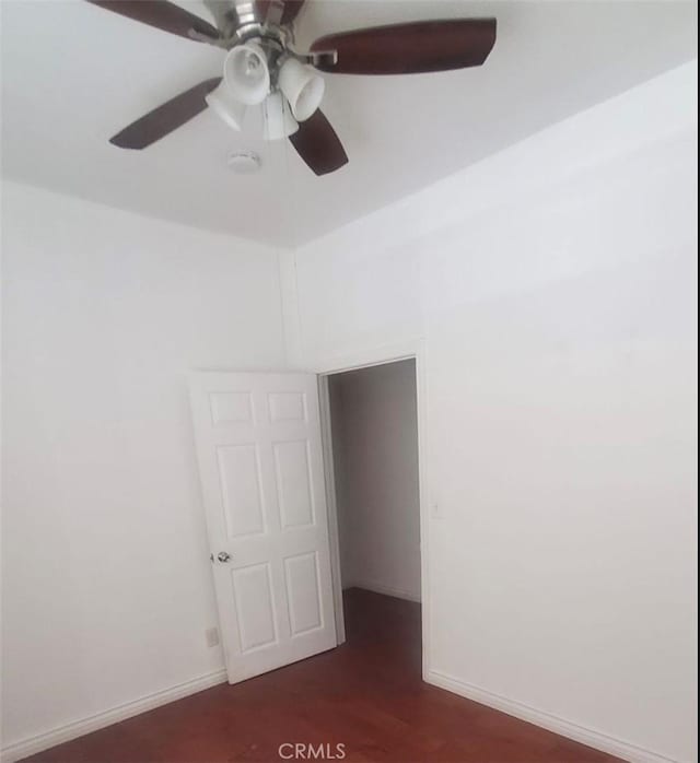 unfurnished room with dark wood-style floors, baseboards, and a ceiling fan