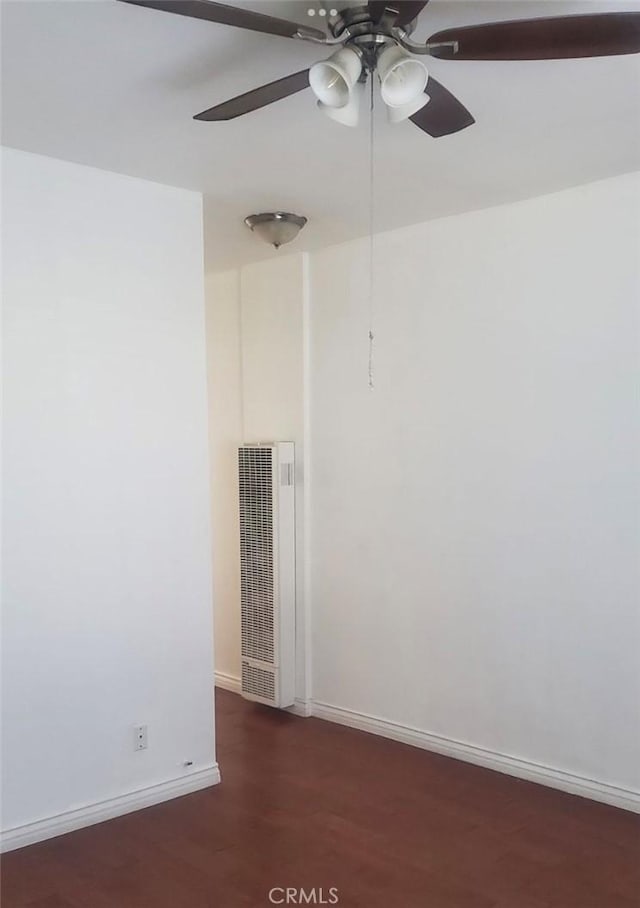 unfurnished room with ceiling fan, dark wood finished floors, visible vents, and baseboards