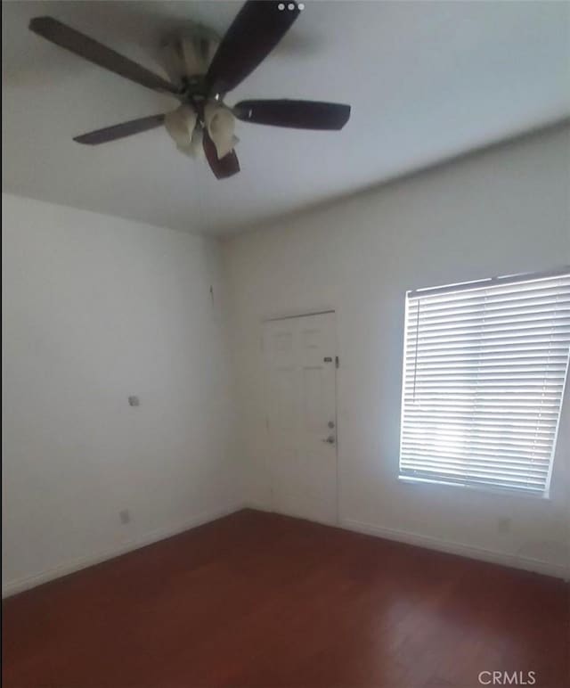 unfurnished room with a ceiling fan and baseboards