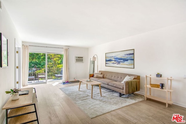 living room featuring a wall unit AC and light wood-type flooring