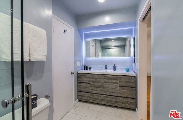 bathroom featuring tile patterned floors, vanity, and toilet