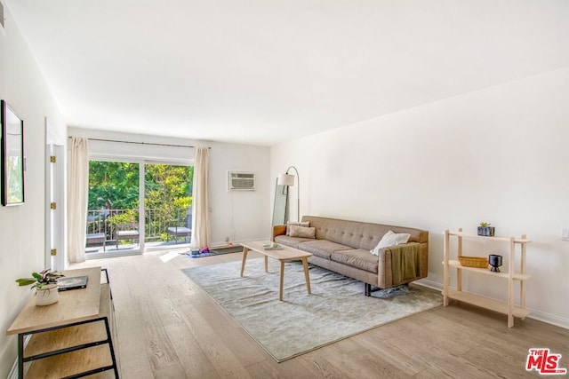 living room with light wood-type flooring and a wall unit AC