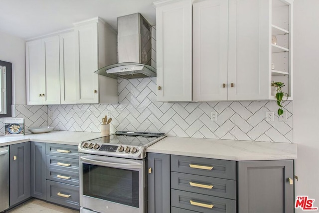 kitchen featuring white cabinets, gray cabinetry, wall chimney exhaust hood, and stainless steel appliances