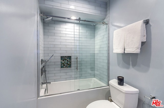 bathroom featuring bath / shower combo with glass door and toilet