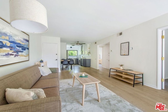 living room featuring ceiling fan and light hardwood / wood-style flooring