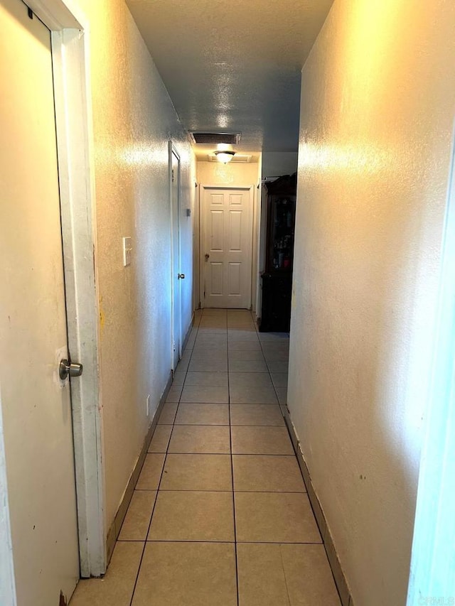 hall featuring light tile patterned floors