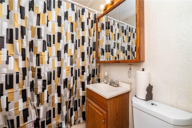 bathroom with vanity, toilet, tile walls, walk in shower, and tasteful backsplash