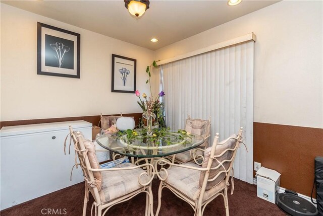 dining room featuring dark colored carpet