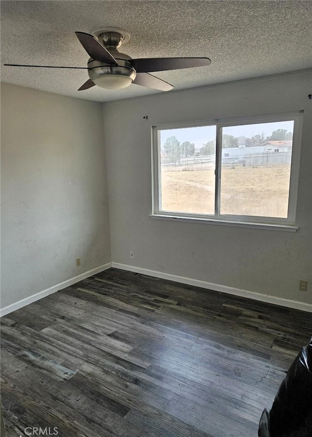 empty room featuring dark hardwood / wood-style flooring, ceiling fan, and a textured ceiling