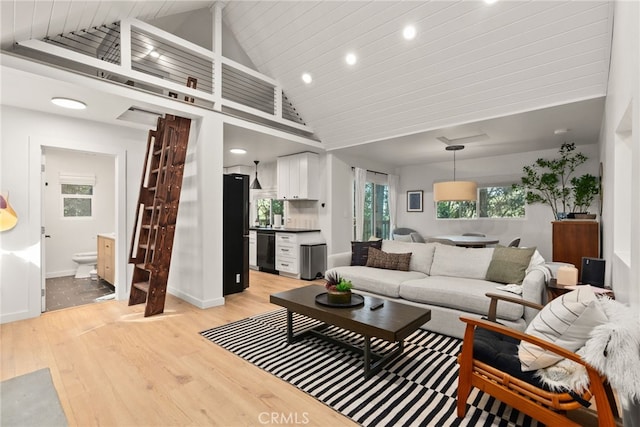 living room with sink, high vaulted ceiling, and light hardwood / wood-style floors