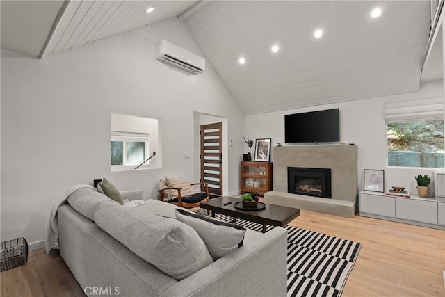 living room featuring hardwood / wood-style flooring, a premium fireplace, a wall mounted AC, and high vaulted ceiling