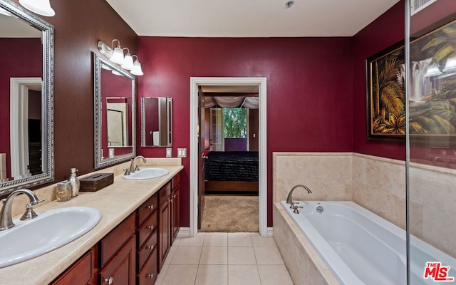 bathroom featuring tile patterned flooring, vanity, and a relaxing tiled tub