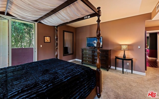 bedroom with carpet floors, lofted ceiling with beams, and access to outside