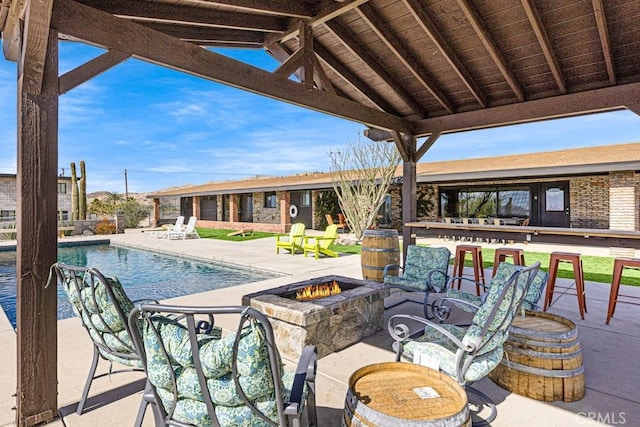 view of pool featuring a patio and an outdoor fire pit