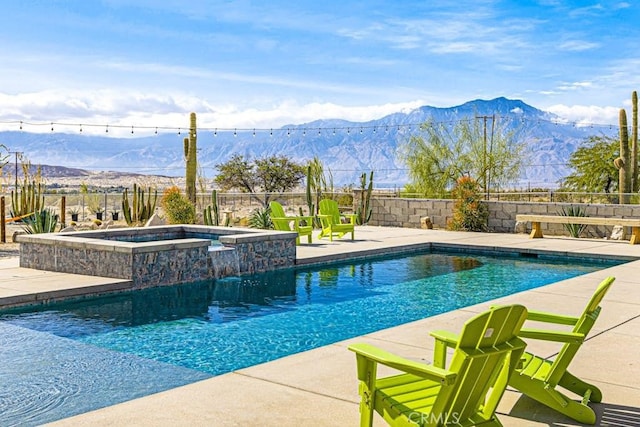 view of pool with a patio, an in ground hot tub, and a mountain view