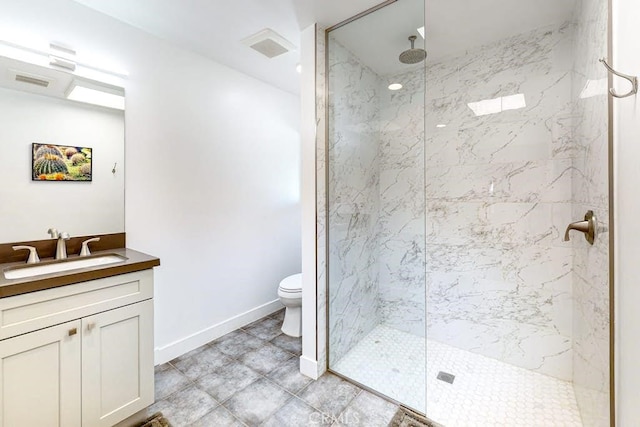 bathroom with a tile shower, vanity, and toilet