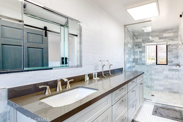 bathroom with tile walls, tiled shower, vanity, and tile patterned flooring