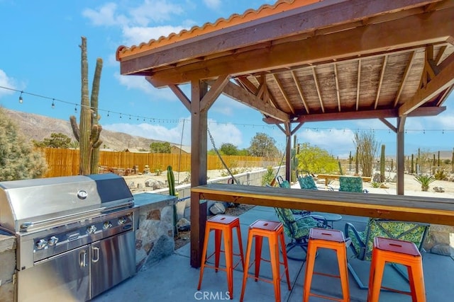 view of patio with a mountain view, grilling area, an outdoor bar, and a gazebo