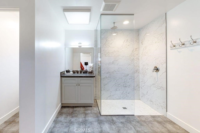 bathroom with a tile shower and vanity