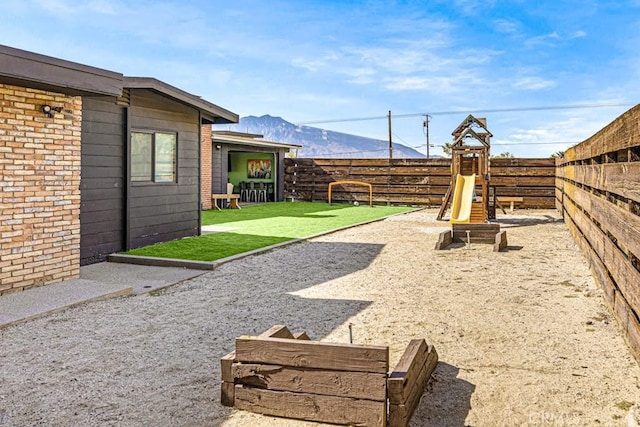 view of yard featuring a playground and a mountain view