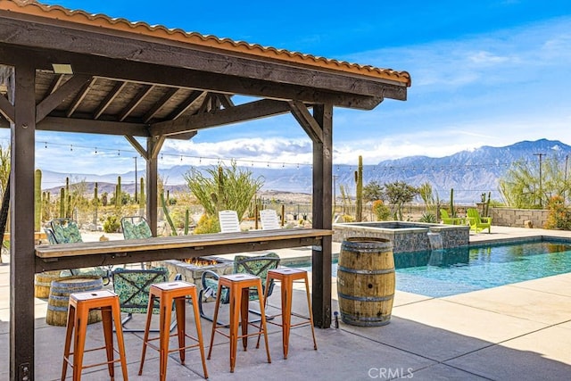 view of pool with a mountain view, a patio, a gazebo, and an in ground hot tub