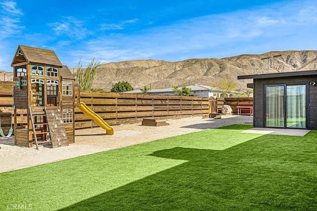 view of yard with a playground and a mountain view