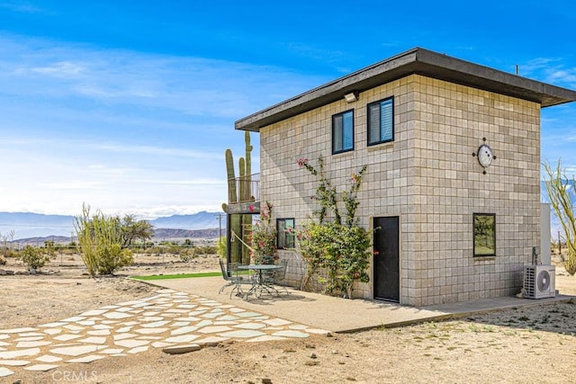 view of property exterior featuring ac unit, a mountain view, and a patio area