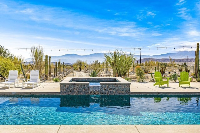 view of swimming pool featuring a mountain view and a patio area