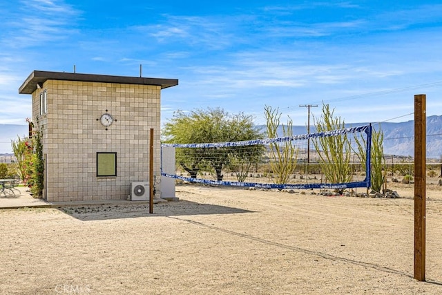 view of home's community with a mountain view, volleyball court, and ac unit