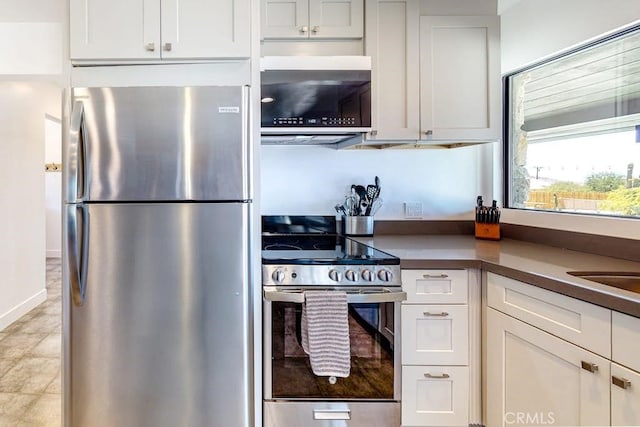 kitchen featuring stainless steel appliances, white cabinetry, and light tile patterned floors