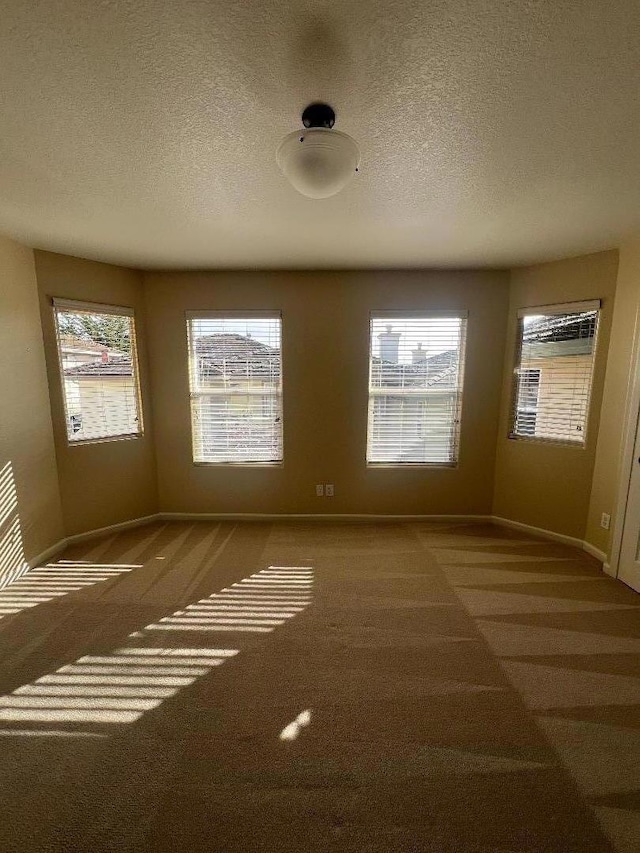 carpeted spare room with a textured ceiling