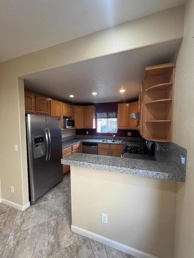 kitchen featuring stainless steel appliances, kitchen peninsula, and sink