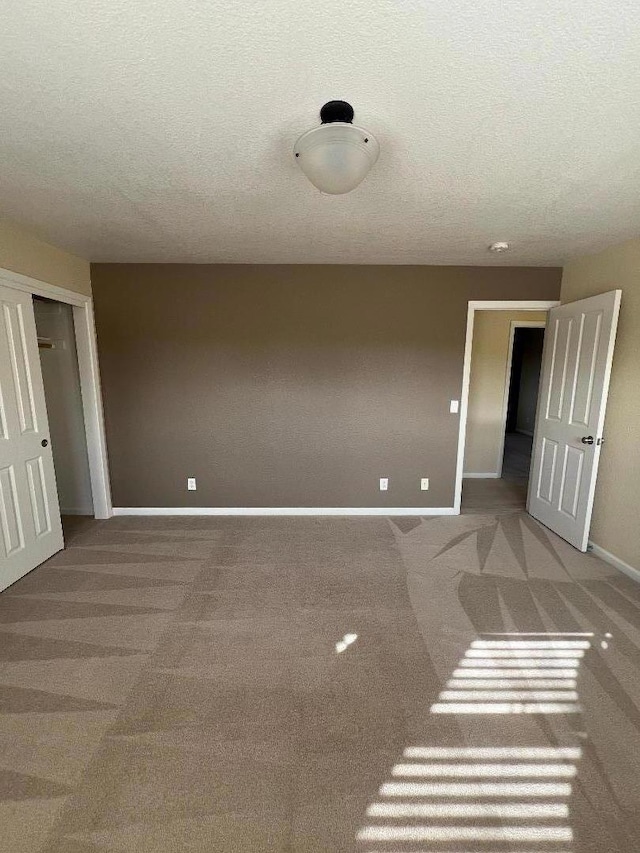 empty room featuring carpet and a textured ceiling