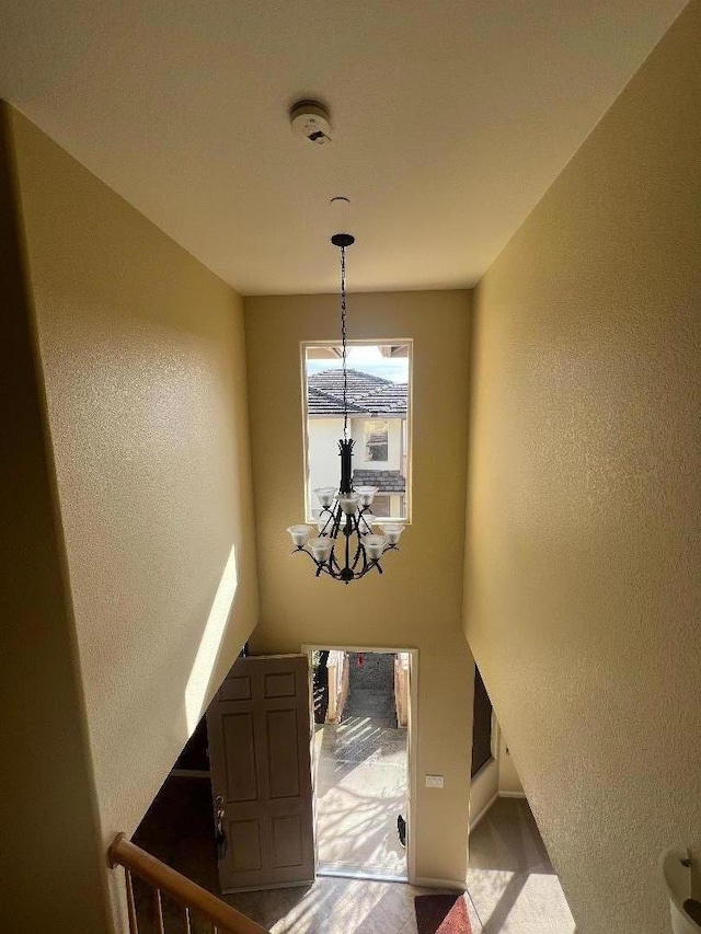 staircase with an inviting chandelier