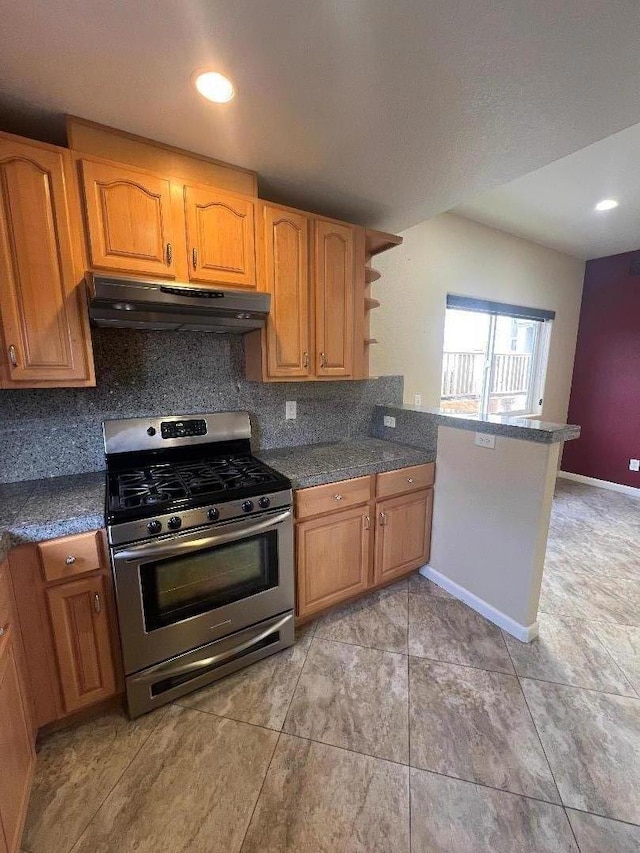 kitchen with gas range, backsplash, and kitchen peninsula