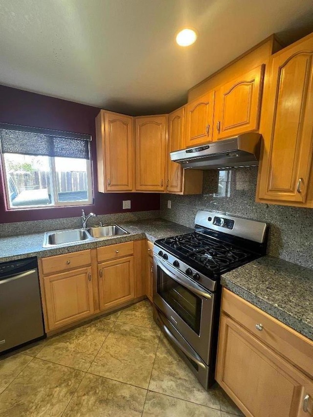 kitchen with light tile patterned flooring, appliances with stainless steel finishes, sink, and decorative backsplash