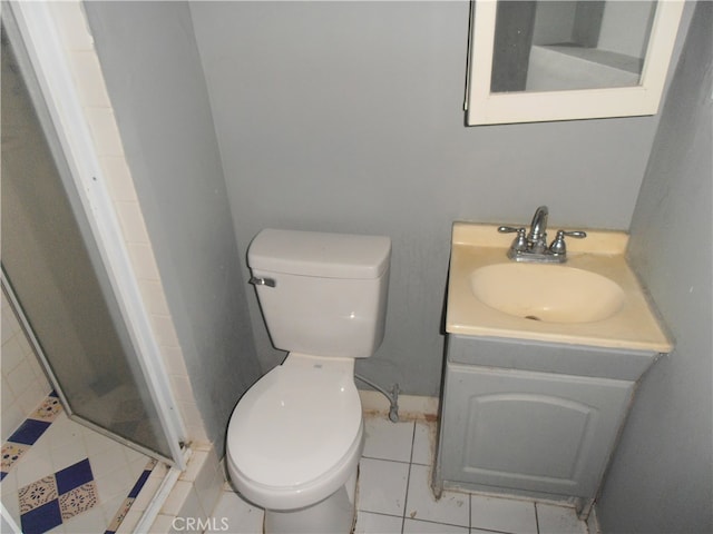 bathroom featuring tile patterned flooring, an enclosed shower, vanity, and toilet