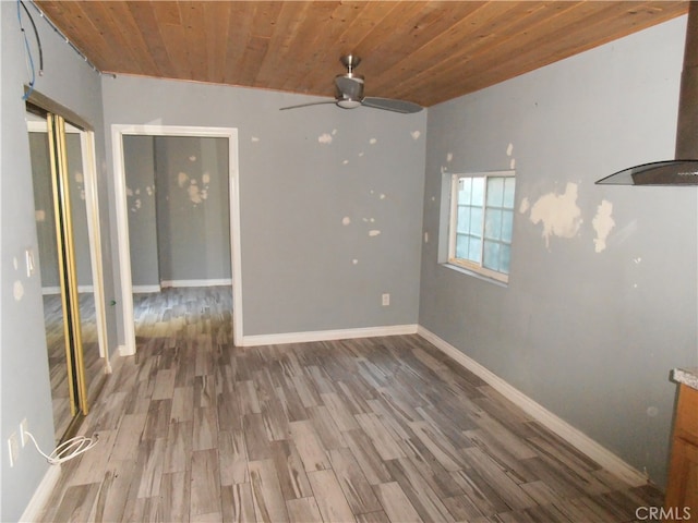 empty room with vaulted ceiling, hardwood / wood-style floors, and wooden ceiling