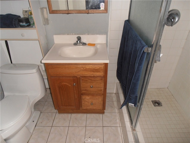 bathroom with walk in shower, vanity, tile patterned flooring, and toilet