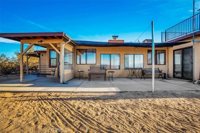 back of property featuring a balcony and a patio