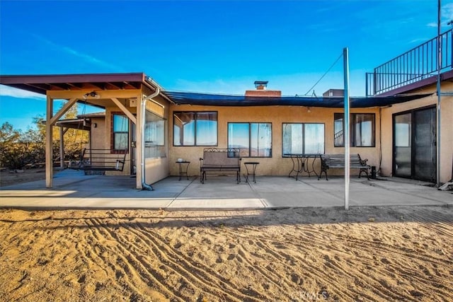 5975 Desert Star Rd Unit 1-2, Johnson Valley, CA 92285 - back of house featuring stucco siding, a chimney, and a patio area
