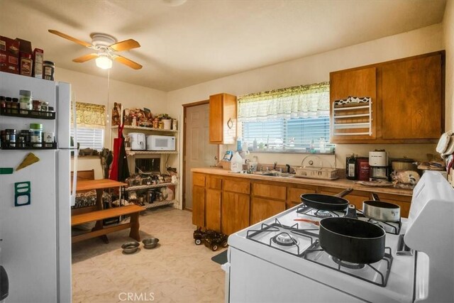5975 Desert Star Rd Unit 1-2, Johnson Valley, CA 92285 - kitchen featuring white appliances, a ceiling fan, brown cabinetry, and a sink