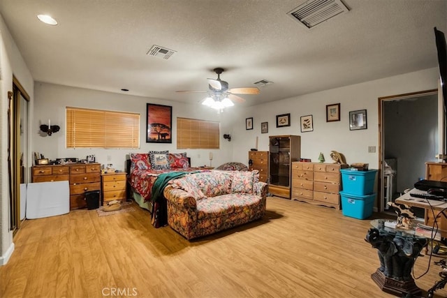 bedroom featuring ceiling fan, a textured ceiling, and light wood-type flooring